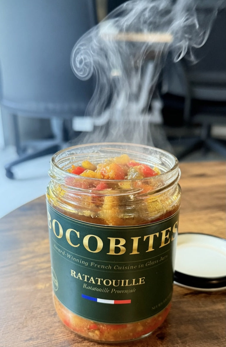 Jar of Cocabites Ratatouille with steam rising, on a wooden surface.